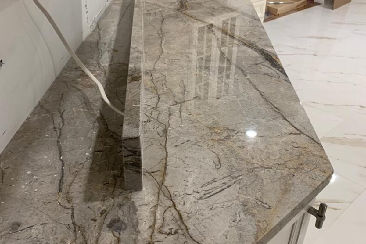 Premium gray marble slab close-up showing dramatic veining